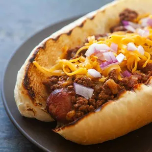 a chili dog with cheese and onions
