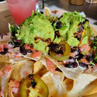 Big Star Nachos with salsa seco drizzled on top. Some of the best quac ever! Yellow Rose Daiquiri in background (yep, it&apos;s pink).