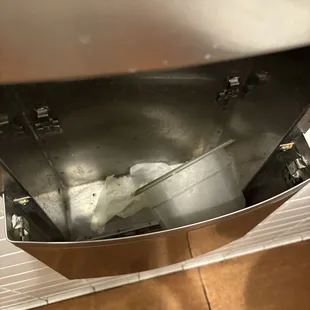 There are some kitchen dishes in the bathroom paper towel trashcan.