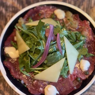 Filet Mignon Carpaccio: Brenton salt, lime pith, Meyer Lemon, olive oil, topped with Arugula, Beaufort ribbon, pickled onion, capers.