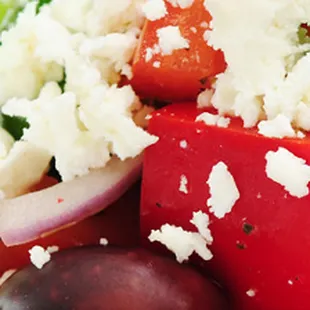 a salad with tomatoes, cucumbers, and feta cheese