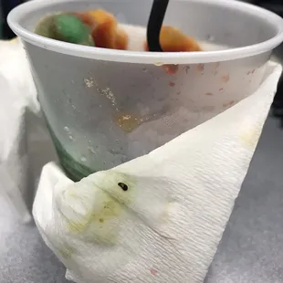 a paper cup with food in it