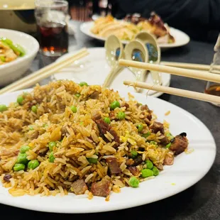 a plate of fried rice with chopsticks