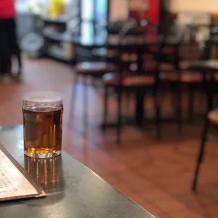 a glass of beer and a menu on a table