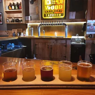 five beers lined up on a bar
