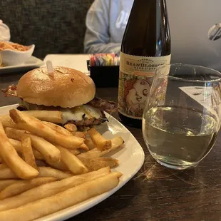 a plate of french fries and a bottle of wine
