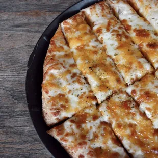 a cheese pizza on a black plate