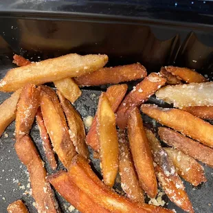 a pile of french fries on a grill