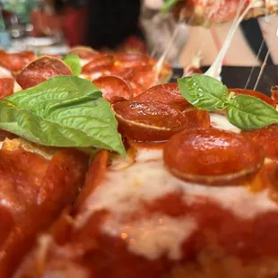 pepperoni and basil on a pizza