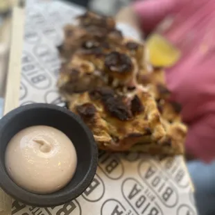 a piece of pizza and a small sauce