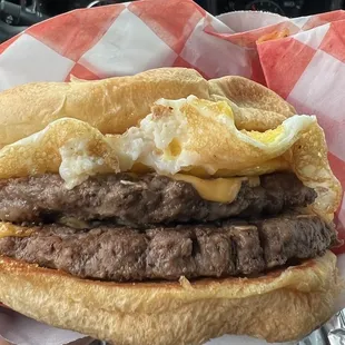 a hamburger with bacon and eggs