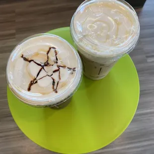 two iced coffees on a green plate