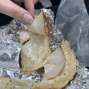 a person putting a piece of bread on top of foil