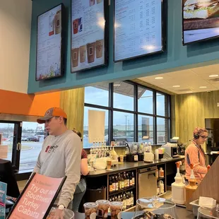 a man standing at a counter in a coffee shop