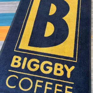 a biggby coffee logo on a doormat