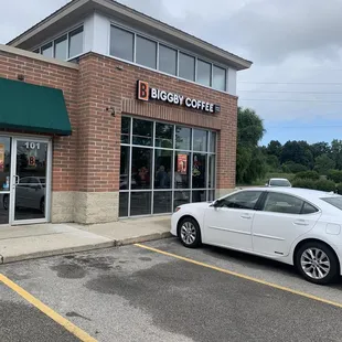 a white car parked in front of a coffee shop