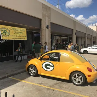 a yellow vw beetle parked in front of a store