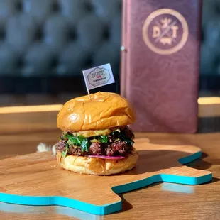 a burger on a wooden cutting board