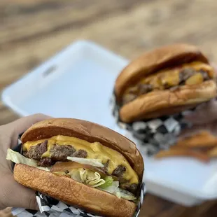 a hand holding a hamburger