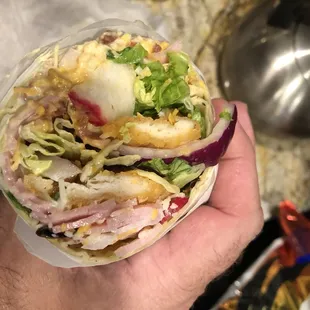 a hand holding a sandwich