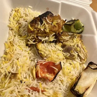 a white styrofoam container filled with rice and vegetables
