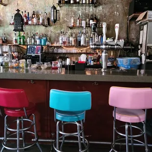 a row of stools in front of a bar
