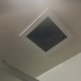 Little green light in vent above toilet in women's restroom