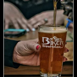 a person pouring beer into a glass