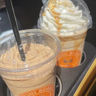 two cups of coffee with whipped cream and caramel