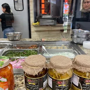 three jars of pickles on a counter