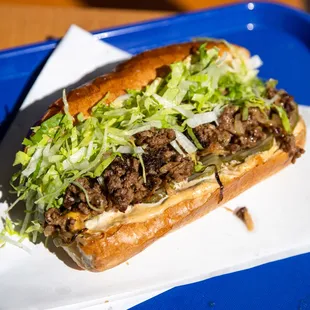 CHOPPED CHEESE--Seared ground beef patty, chopped with caramelized onion, American cheese, iceberg, spicy garlic dill pickles on french roll