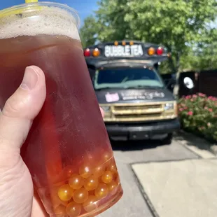 a hand holding a cup of bubble tea