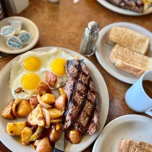 Steak and egg with country potatoes.