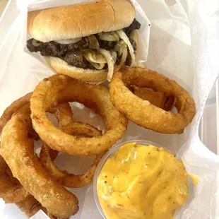 a sandwich with onion rings and mustard