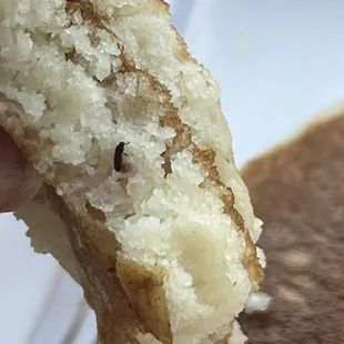 a hand holding a half eaten sandwich