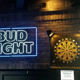 a neon sign and a dart board