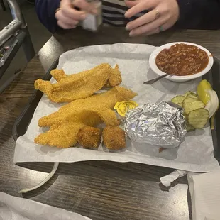 Catfish and corn on the cob with baked beans.
