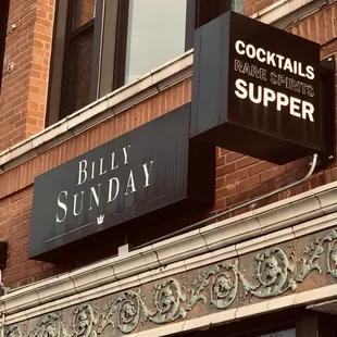 a brick building with a sign for a bar