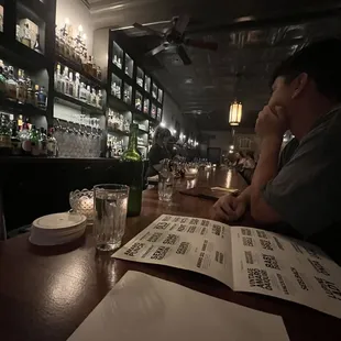 a man sitting at a bar with a menu in front of him