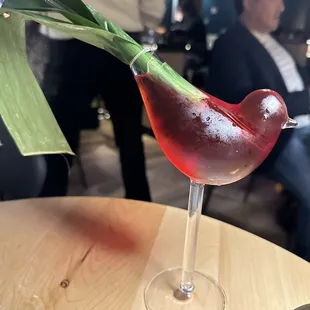 a glass of red wine with a green stem