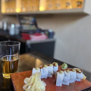 a glass of beer and a plate of sushi