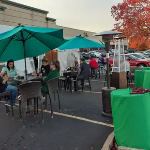 people sitting at tables under umbrellas