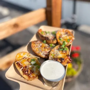 a hand holding a tray of mini pizzas