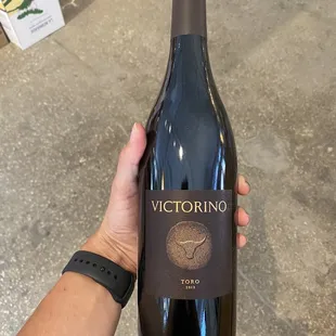 a hand holding a bottle of wine