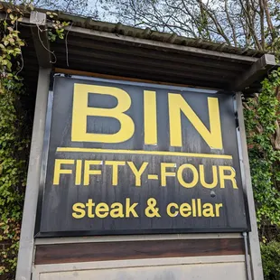 Bin 54 sign in Glen-Lennox Shopping Center parking lot.