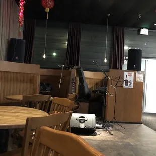 a room with a table, chairs, speakers, and a speaker system