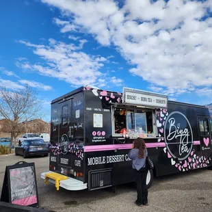 a woman standing in front of a food truck