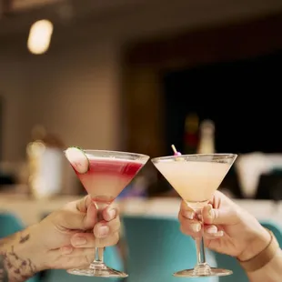 two people toasting with cocktails
