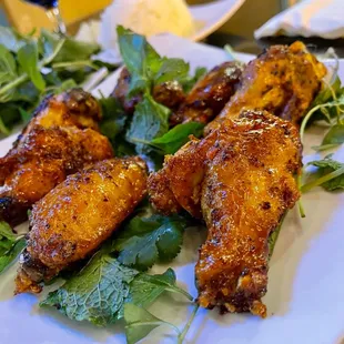 a plate of chicken wings and greens