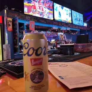 a can of beer sitting on a bar